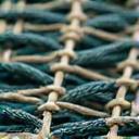 A close-up of a meticulously hand-woven fishing net.