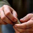 An artisan shaping a traditional wooden fishing tool.